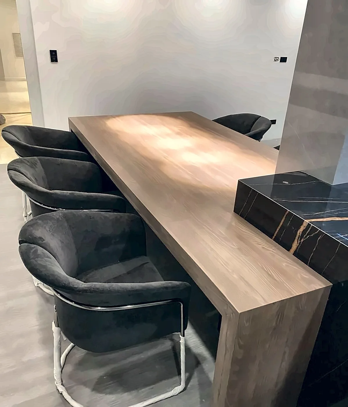 Barra comedor en madera junto a la isla de mármol